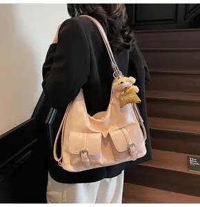 Detail einer großen rosa Hobo-Tasche mit Schnallentaschen und Plüschbär-Anhänger
