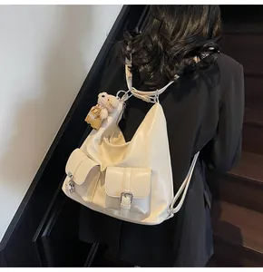 Detail eines cremigen beigen Lederrucksacks mit doppelten vorderen Schnallentaschen