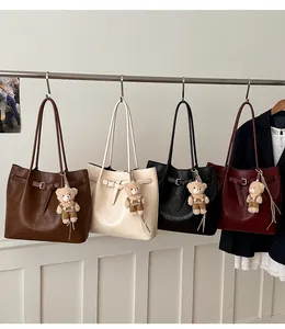 Multiple colors of large capacity tote bags in faux leather with teddy bear charms
