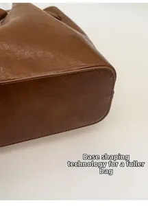 Detail of reinforced bottom base on brown leather tote for a structured fuller shape