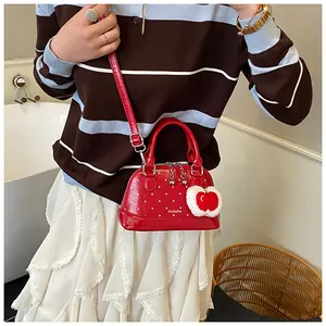 Detail der roten Polka-Dot-Mini-Muscheltasche mit Tragegriffen und abnehmbarem Schultergurt