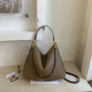 Chic brown large tote bag with golden chain strap and pebbled leather texture