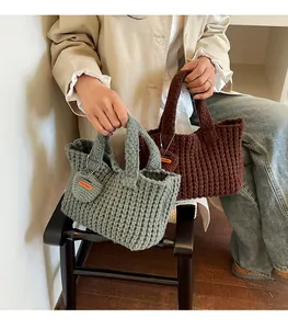 Detailed macro view of woven knit mini handbags in green and brown with handmade tags