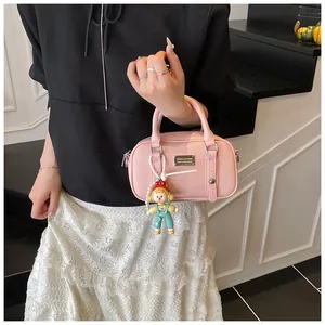 Roze mini Boston tas van getextureerd leer met handvaten en een poppenhangertje