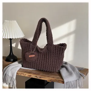 Detailed macro view of dark coffee knitted tote with a handmade heart-shaped charm