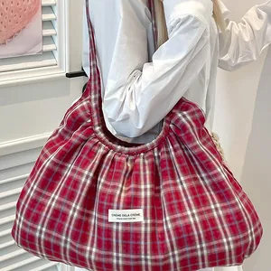 Grand sac à bandoulière à carreaux rouges avec des plis et une étiquette en tissu
