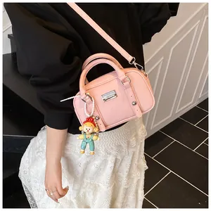 Roze Boston tas van lychee generfd leer met een schattige poppenhanger en zilveren logo