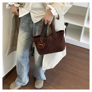 Detail of dark brown knitted handbag texture with a Hand Made tag on a woven strap