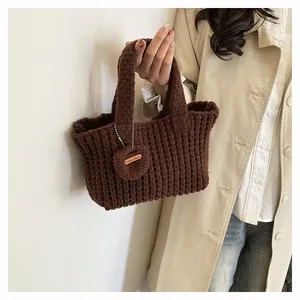 Detail of hand-knitted brown tote bag featuring texture and a Hand Made label