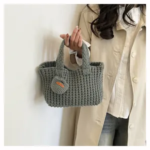 Close-up of gray knit handbag texture and Hand Made leather heart charm detail