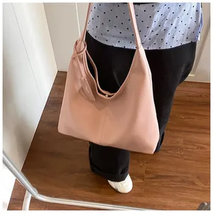Détail du sac cabas rose texture litchi avec large bandoulière et étiquette cuir