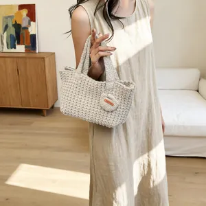 Handmade beige crochet tote bag with a knitted heart pendant and a Hand Made leather label