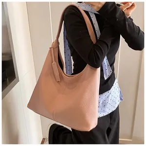 Détail du sac cabas en cuir rose grainé montrant la texture et l'étiquette latérale
