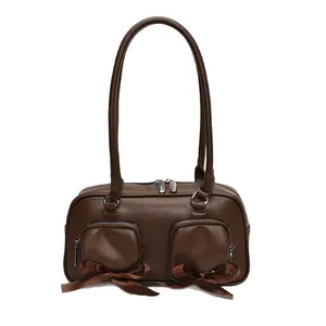 Brown faux leather Boston tote bag with decorative front pockets and satin bows