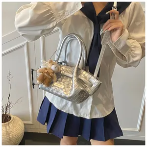 Sac seau tressé argenté avec un pendentif ours en peluche et texture métallique