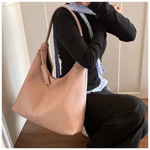 Détail de la texture grainée sur un grand sac cabas rose en similicuir avec étiquette