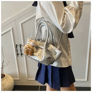 Détail du sac panier tressé argenté au fini métallique avec pendentif ours en peluche