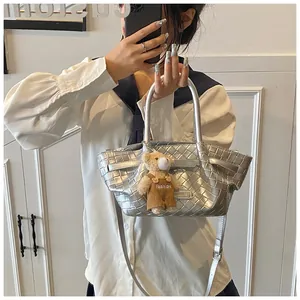 Selfie miroir montrant un sac seau tressé argenté avec breloque ours et bandoulière
