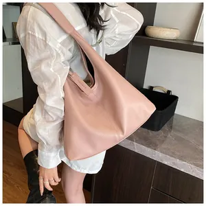 Détail du sac cabas rose texture litchi avec étiquette en cuir et bandoulière intégrée
