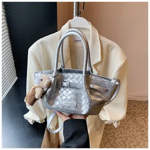 Sac seau tressé argenté avec logo métallique et adorable breloque ours en peluche