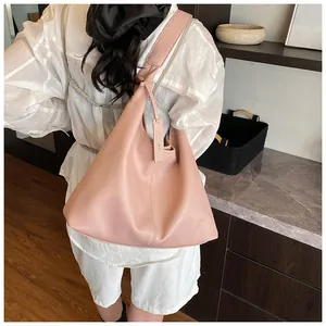 Détail de sac cabas rose en cuir grainé avec pendentif latéral élégant et épuré