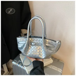 Détail de la texture en cuir tressé argenté et de la boucle sur un sac seau de créateur