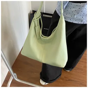 Détail de sac cabas vert avocat en cuir grainé avec couture verticale et étiquette