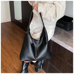 Gros plan d'un sac hobo noir en cuir grainé avec un détail d'étiquette de marque