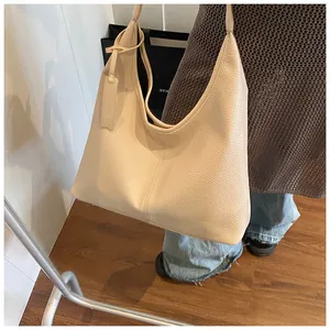 Vue détaillée du grand sac hobo crème avec texture grainée et sangle à nœud
