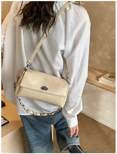 Détail du sac bandoulière en cuir PU crème avec fermoir rotatif argenté et chaîne
