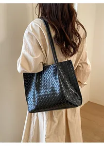 Gros plan sur le sac cabas tressé noir montrant la texture et le tissage carré