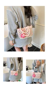 Close-up of handmade crochet shoulder bag with pink tulip patterns and floral charm