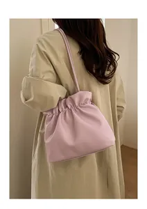 Detail view of a lavender bucket bag with drawstring closure and slim shoulder strap