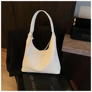 Détail du grain de litchi sur un grand sac cabas blanc crème avec bandoulière élégante