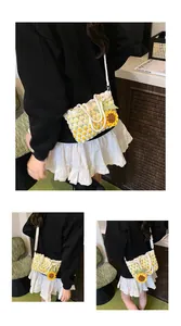 Detail of woven sunflower shoulder bag with pearl handle and yellow checkered pattern