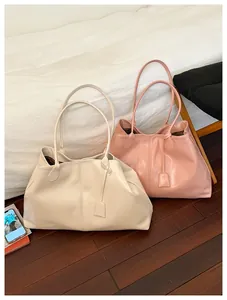 Detail view of large tote bags in cream and dusty rose with elegant hanging tags