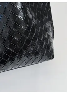 Vue détaillée du fourre-tout en cuir tressé noir avec fini brillant et texture ferme