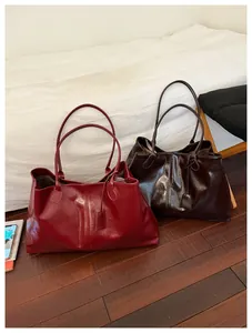 Detail view of large tote bags in dark red and brown with glossy leather texture