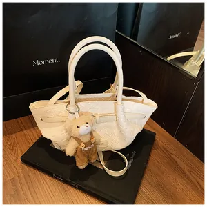 Détail du sac seau tressé crème avec une peluche ours et une poignée ronde