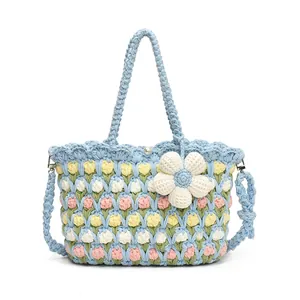 Detail of woven tote bag with tulip patterns, pearl clasp, and sunflower charm accessory