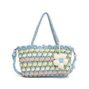 Detail of light blue crochet tulip bag with white pearl clasp and flower pendant
