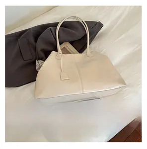 Detail showing an off-white large capacity tote bag with dual straps and soft texture