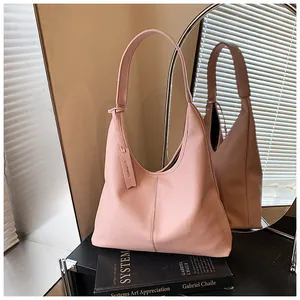 Détail d'un sac cabas en cuir grainé rose avec coutures verticales et étiquette de marque