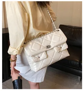 Detailed view of white quilted chain bag with high-gloss leather and silver turn-lock