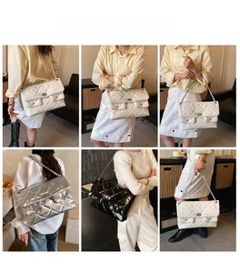 Detail view of quilted chain bag in white, silver and black with metal rotary lock