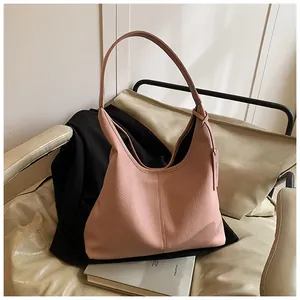 Gros plan sur le cuir grainé rose et l'étiquette latérale de ce grand sac fourre-tout