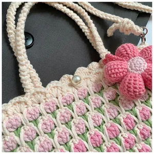Detailed close-up of handmade crochet bucket bag with tulip pattern and pearl closure