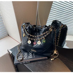 Détail du sac seau matelassé avec bretelles chaîne dorées et breloques cœur