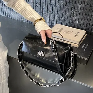 Sac sous le bras en cuir verni noir brillant avec fermoir argenté et double bandoulière