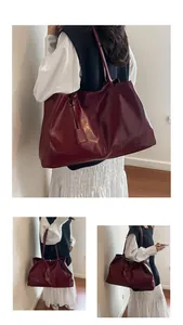 Detail of dark red tote bag in oily leather texture with decorative hanging tag
